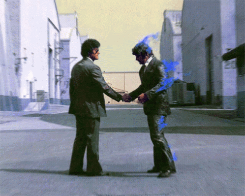 Two Men In Suits Shake Hands On A Street GIF