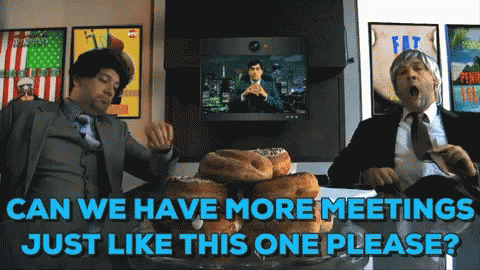 Two Men in Suits Sitting at Table With Donuts Saying Can We Have More Meetings Just Like This One Please