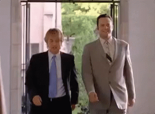 Two Men in Suits Smiling Holding Hands