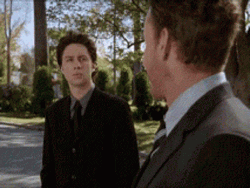Two Men In Suits Standing Together GIF