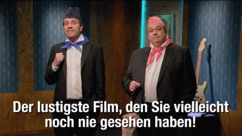 Two Men In Suits Standing Together With Der Lustigste Film Den Sie Vielleicht Noch Nie Gesehn Ha GIF