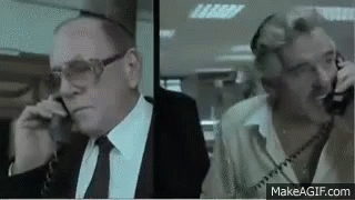 Two Men in Suits Talking on Phones