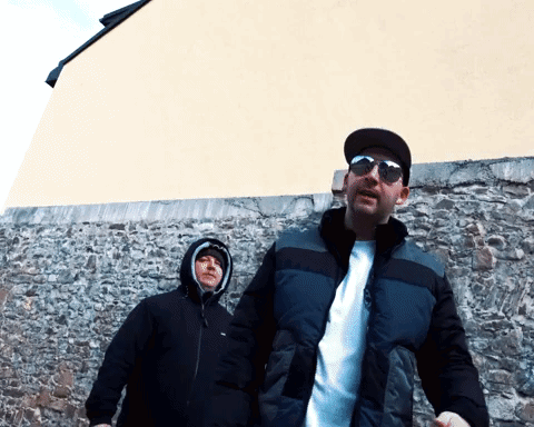 Two Men in Sunglasses in Front of Stone Wall