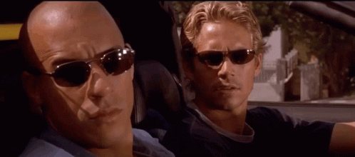 Two Men in Sunglasses Looking at Each Other in Car