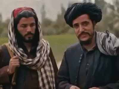 Two Men In Turbans And Scarves Talking GIF