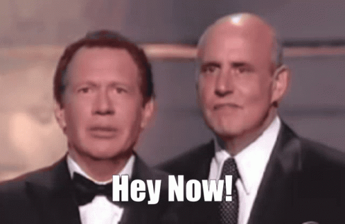 Two Men In Tuxedos Are Standing Next To Each Other With The Words Hey Now Written On Their Faces GIF