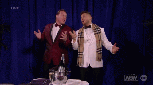 Two Men In Tuxedos With Blue Curtain Saying Live GIF