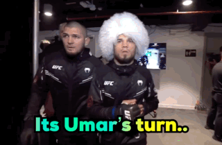 Two Men In Ufc Jackets Are Walking In A Room With The Words " Its Umar 'S Turn " On The Bottom GIF