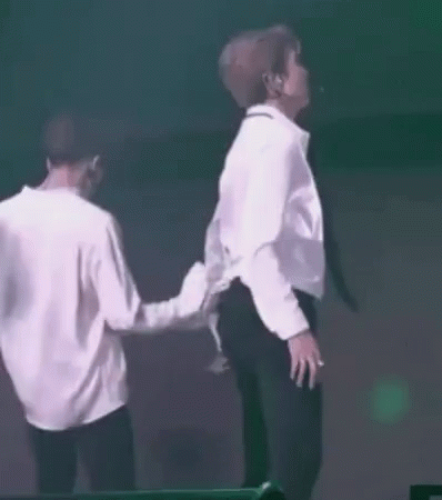 Two Men in White Shirts and Black Pants Dancing in Front of Green Light