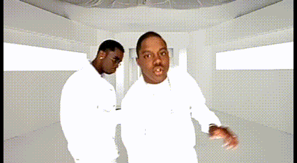 Two Men In White Shirts Are Dancing Together In A White Room GIF