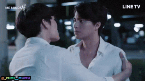 Two Men in White Shirts Hugging in Front of Line TV Screen