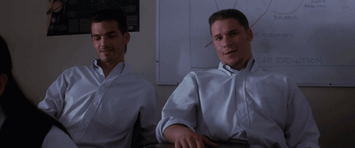 Two Men In White Shirts Sit In Front Of A White Board That Says " Car Evolution " GIF