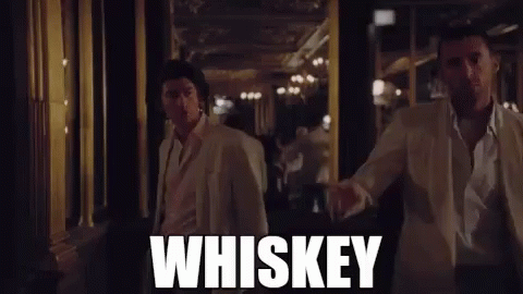 Two Men in White Suits Walking Down Whiskey Hallway