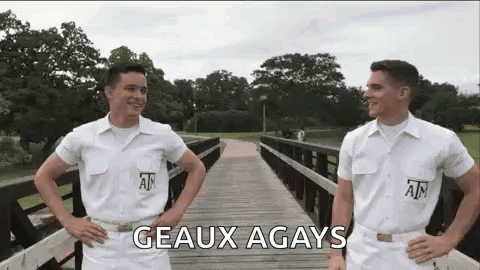 Two Men in White Uniforms Standing on a Bridge
