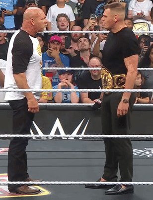 Two Men in Wrestling Ring One with Gold Belt