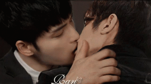 Two Men Kissing In Front Of Ran Sign GIF