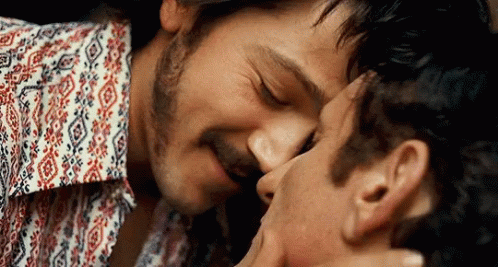 Two Men Kissing One Wearing Floral Shirt