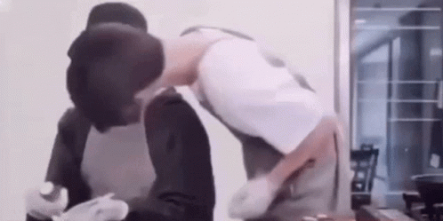 Two Men Kissing While Cooking