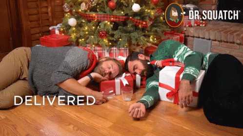 Two Men Laying in Front of Christmas Tree Dr. Squatch