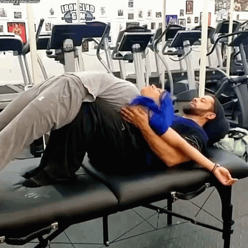 Two Men Laying on Gym Bench With Iron Clad Sign