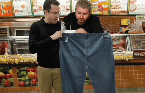 Two Men Looking At A Pair Of Jeans In A Subway Store GIF