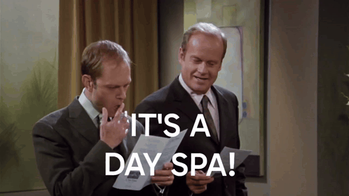 two men looking at a piece of paper with the words it 's a day spa on it