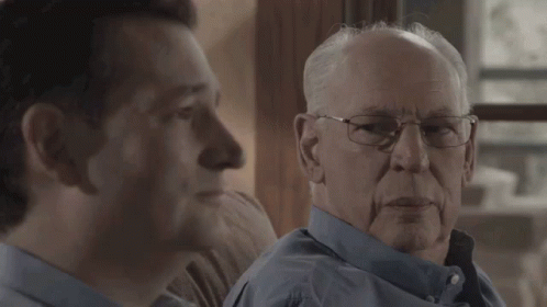 Two Men Looking at Each Other One With Glasses