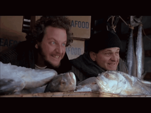 Two Men Looking at Fish Beside Seafood Box