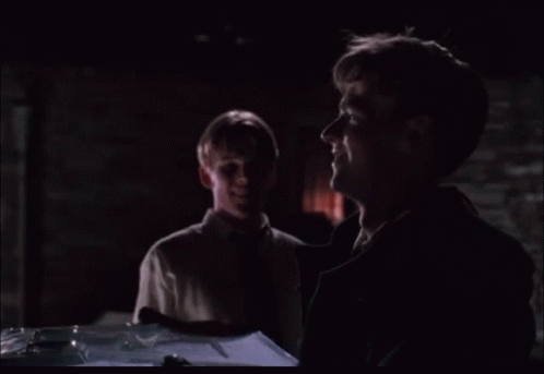 Two Men Looking at Something in Dark Room