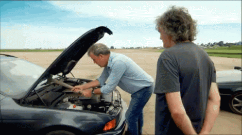 Two Men Looking Under The Hood Of A Car With The Hood Open GIF