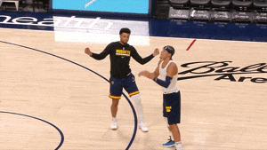 Two Men On A Basketball Court One Wearing A Shirt That Says Denver Nuggets GIF