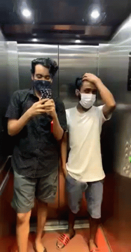 Two Men On Phones, One In Kona Shirt GIF