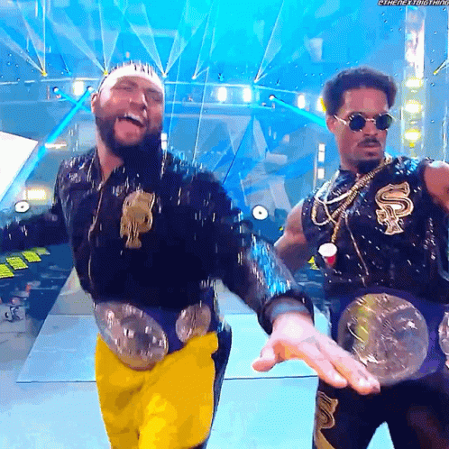 Two Men on Stage, One With Smackdown Belt