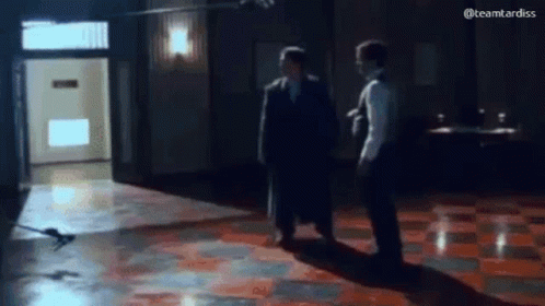 Two Men on Tiled Floor in Dark Room