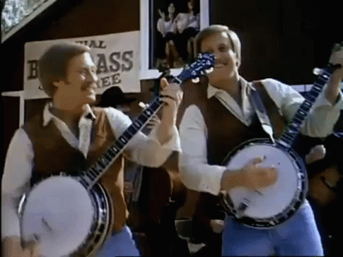 Two Men Playing Banjo And Guitar In Front Of Brass Sign GIF