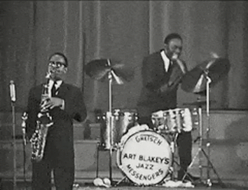 Two Men Playing Saxophone And Drums In Jazz Band GIF