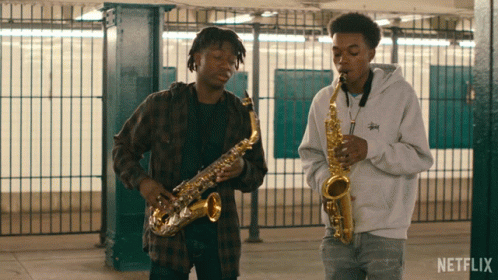 Two Men Playing Saxophones In A Netflix Video GIF