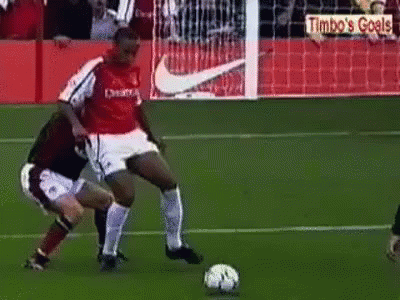 Two Men Playing Soccer With Timbo's Goals Sign