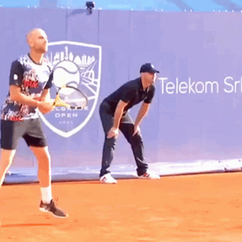 Two Men Playing Tennis in Front of Telekom Ad