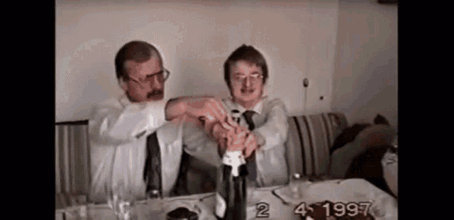 Two Men Popping Champagne GIF