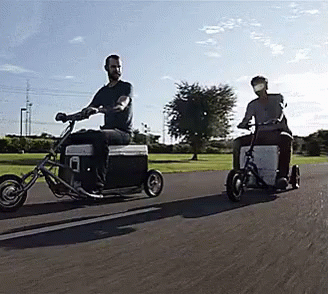 Two Men Riding Motorcycles With Coolers Attached