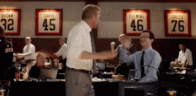 Two Men Shake Hands In Front Of A Wall With Jerseys For Davis And Fleming On It GIF