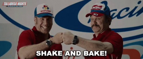 Two Men Shaking Hands in Front of Talladega Nights Sign