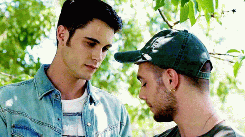 Two Men Side by Side, One in Green Hat
