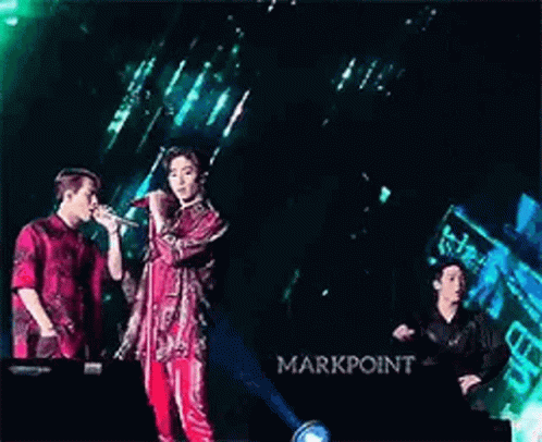 Two Men Singing Into Microphones on Stage