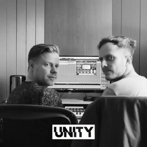 Two Men Sitting at Computer With Unity Above