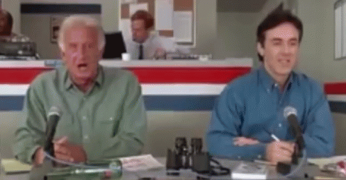 Two Men Sitting at Desk With Microphones