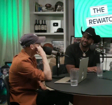 Two Men Sitting at Rewards Sign