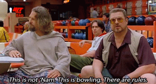 Two Men Sitting At Table In Bowling Alley GIF