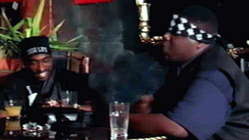 Two Men Sitting at Table With Drinks Snoop Dogg Bandana